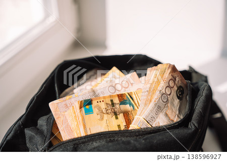 Close up stack of Kazakhstani tenge banknotes in an open black bag, money and budgeting concept Close up stack of Kazakhstani tenge banknotes in an open black bag, money and budgeting concept 138596927