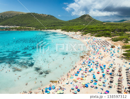 Aerial view of a crowded sandy beach with colorful umbrellas 138597312