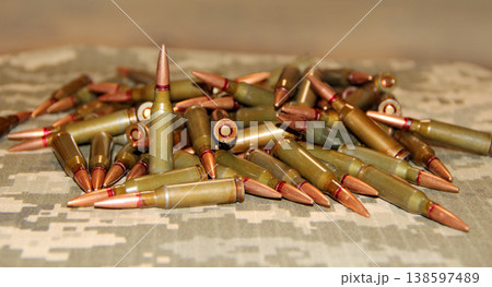 Cartridges for Kalashnikov assault rifle. War Concept. Heap of billets Cartridges for Kalashnikov assault rifle. War Concept. Heap of billets 138597489