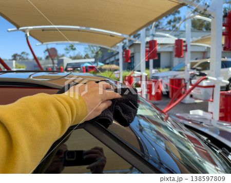 Man wiping and drying car with grey microfiber rag outdoors, closeup Man wiping and drying car with grey microfiber rag outdoors, closeup 138597809