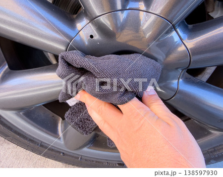 Man wiping and drying car with grey microfiber rag outdoors, closeup Man wiping and drying car with grey microfiber rag outdoors, closeup 138597930