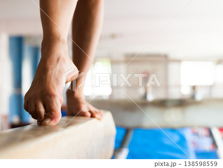Tensed legs and pointed toes of female gymnast balancing on beam Tensed legs and pointed toes of female gymnast balancing on beam 138598559