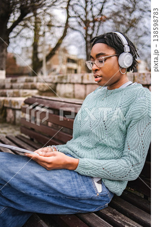 Young Black adult woman learning with tablet at park 138598783