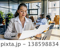 Focused Female Analyzing Charts Meticulously. Woman Carefully Inspecting Printed Data And Diagrams 138598834