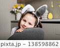 Cute girl in bunny ears leaning on chair in kitchen interior 138598862