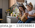 Two sisters with bunny ears holding Easter basket at home 138598863