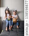 Two sisters with bunny ears holding Easter basket at home 138598877