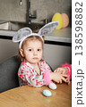 Little girl in bunny ears holding Easter eggs basket at home 138598882
