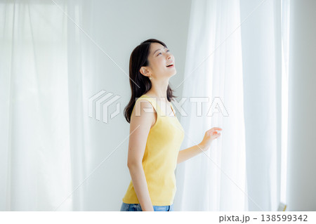 カーテンを開ける女性 138599342