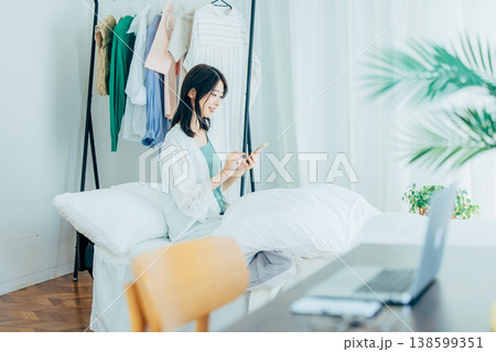 ベッドでスマホを見る若い女性 138599351