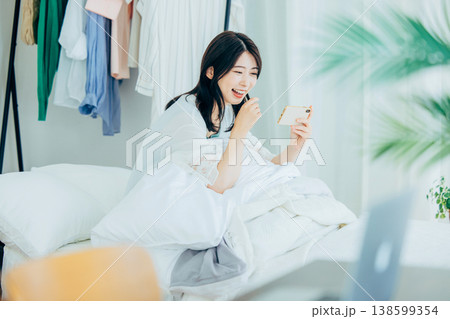 ベッドでスマホを見る若い女性 138599354