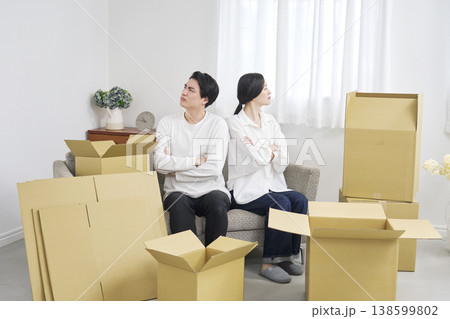 引越し中に背中合わせで腕を組む不満げな夫婦 138599802