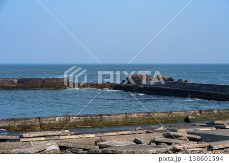 海沿いの堤防と消波ブロックが並ぶ港の風景 海沿いの堤防と消波ブロックが並ぶ港の風景 138601594