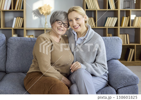 Happy senior mother and adult daughter hugging on cozy home sofa, family love 138601825