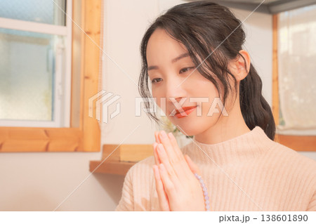 自宅で故人に祈りを捧げる娘（レトロ風） 138601890