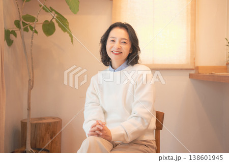 自宅で故人に祈りを捧げた後のミドル女性(レトロ風) 自宅で故人に祈りを捧げた後のミドル女性(レトロ風) 138601945