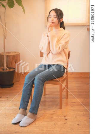 自宅で故人に祈りを捧げる娘（レトロ風） 138601971
