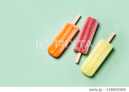 Colorful fruit popsicles on green background Colorful fruit popsicles on green background 138602068