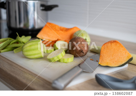 Top view of fresh vegetables being chopped on cutting board in home kitchen Top view of fresh vegetables being chopped on cutting board in home kitchen 138602087
