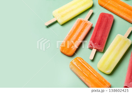 Colorful fruit popsicles on green background 138602425