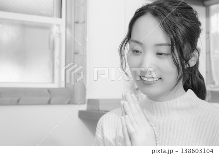 自宅で故人に祈りを捧げる娘(モノクロ) 自宅で故人に祈りを捧げる娘(モノクロ) 138603104