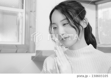 自宅で故人に祈りを捧げる娘(モノクロ) 自宅で故人に祈りを捧げる娘(モノクロ) 138603105