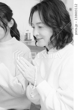 自宅で故人に祈りを捧げる母と娘(モノクロ) 自宅で故人に祈りを捧げる母と娘(モノクロ) 138603112