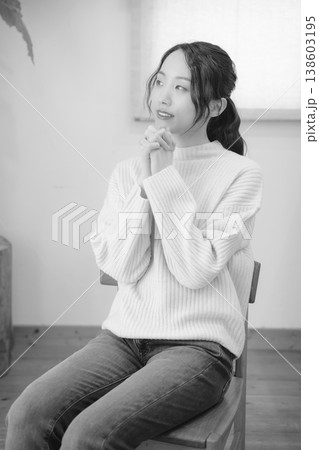 自宅で故人に祈りを捧げる娘（モノクロ） 138603195