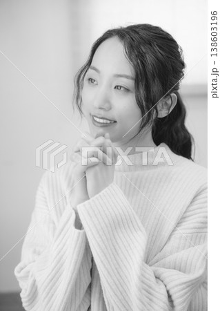 自宅で故人に祈りを捧げる娘（モノクロ） 138603196