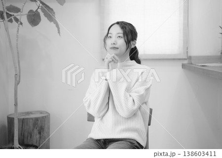 自宅で故人に祈りを捧げる娘(モノクロ) 自宅で故人に祈りを捧げる娘(モノクロ) 138603411