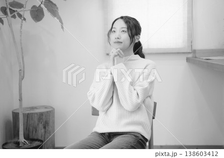 自宅で故人に祈りを捧げる娘(モノクロ) 自宅で故人に祈りを捧げる娘(モノクロ) 138603412