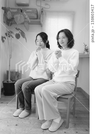 自宅で故人に祈りを捧げる母と娘(モノクロ) 自宅で故人に祈りを捧げる母と娘(モノクロ) 138603417