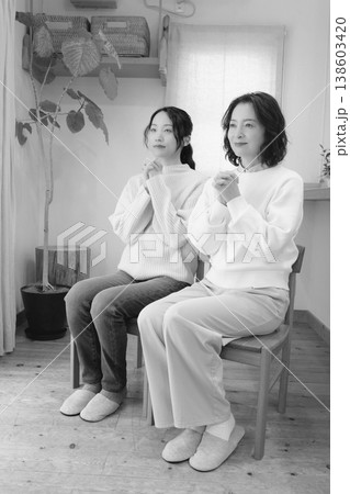 自宅で故人に祈りを捧げる母と娘(モノクロ) 自宅で故人に祈りを捧げる母と娘(モノクロ) 138603420