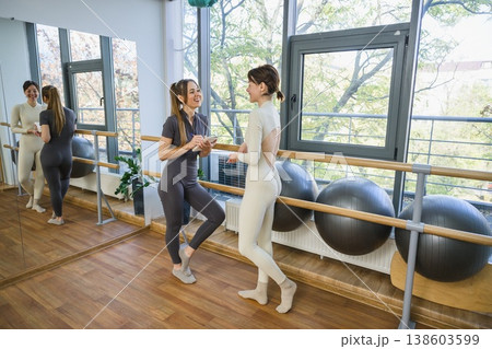 Female trainer taking notes while talking to client in fitness studio. Female trainer taking notes while talking to client in fitness studio. 138603599