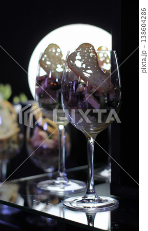 Fresh appetizer with crouton in elegant wine glasses illuminated on black background 138604286