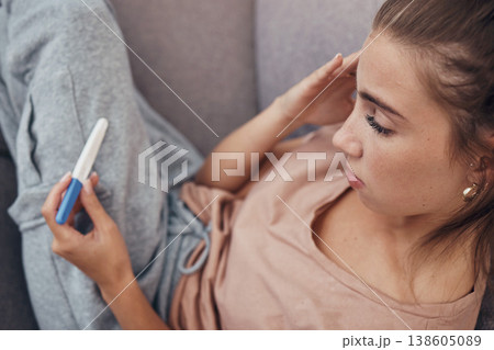 Pregnancy test, sad and woman on sofa in home, reading bad news or negative results. Stick, serious and frustrated pregnant mother depressed in living room for fail, stress or anxiety for infertility 138605089