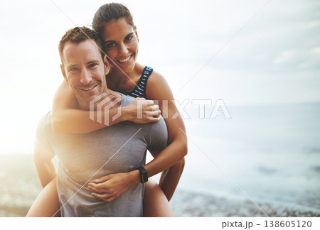 Portrait, piggy back and couple with vacation, outdoor and lens flare with happiness, holiday and bonding. Face, man carrying woman and adventure with beach, hug and outside with wellness and freedom 138605120