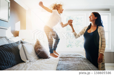 Pregnant woman, holding hands and kid jumping on bed for love, fun and bonding together. Happy, mother and support child for playful morning, emotional connection and supervision on maternity in home 138605586