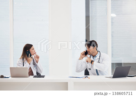 Doctors, talking and people with phone call in office with confidential, info and gesture to whisper. Medical, nurse and busy with administration and frustrated employees with noise or telehealth Doctors, talking and people with phone call in office with confidential, info and gesture to whisper. Medical, nurse and busy with administration and frustrated employees with noise or telehealth 138605711