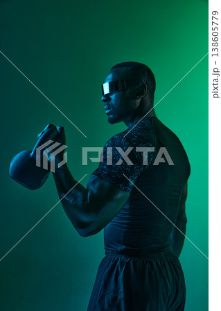 Athlete holding kettlebell showing arm strength in functional fitness workout in neon space Athlete holding kettlebell showing arm strength in functional fitness workout in neon space 138605779