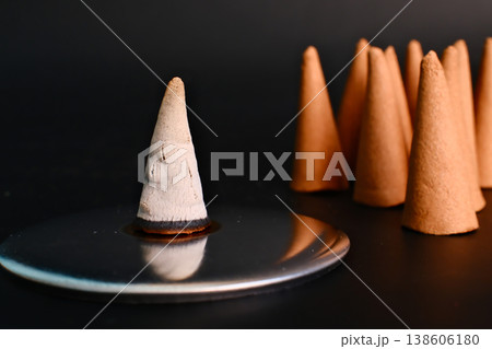 burnt and whole incense sandalwood cones on black background 138606180