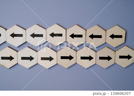 Opposing arrows on wooden blocks symbolize disagreement, rivalry, and the challenge of choosing the right path 138606207