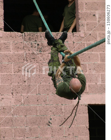 Army, soldier and training with rope obstacle for fitness, exercise or challenge outdoor upside down. Military, man and climbing with physical workout, mission or bootcamp for survival from building Army, soldier and training with rope obstacle for fitness, exercise or challenge outdoor upside down. Military, man and climbing with physical workout, mission or bootcamp for survival from building 138606273