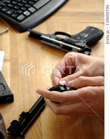 Man, hands and bullet for a gun at a table with military training, battle and conflict. Army, police and pistol with a male tactical expert of a hero with weapon for shooting range and warrior gear Man, hands and bullet for a gun at a table with military training, battle and conflict. Army, police and pistol with a male tactical expert of a hero with weapon for shooting range and warrior gear 138606398