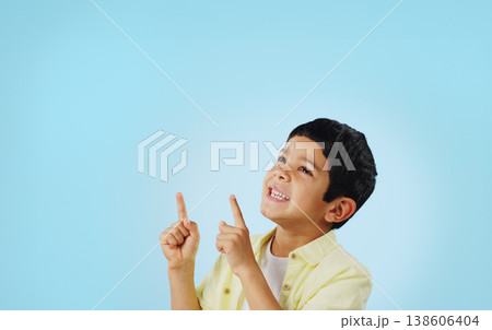 Kid, boy and smile while pointing in studio on blue background with mockup for announcement, offer or deal. Youth, happy and excited about notification on social media, online or digital marketing 138606404