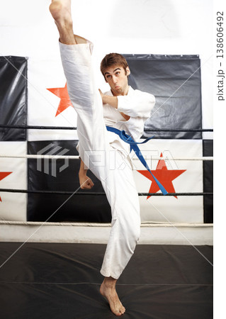 Man, karate and high kick for martial arts in ring, self defense or jiujitsu training for fighting match. Male person, athlete or fighter in MMA boxing, muay thai or fitness practice at dojo or gym Man, karate and high kick for martial arts in ring, self defense or jiujitsu training for fighting match. Male person, athlete or fighter in MMA boxing, muay thai or fitness practice at dojo or gym 138606492
