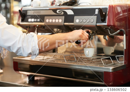 Coffee machine, closeup and man barista in a cafe making latte, cappuccino or espresso in a cup. Equipment, mug and zoom of male waiter or small business owner working on an order in a restaurant. 138606502