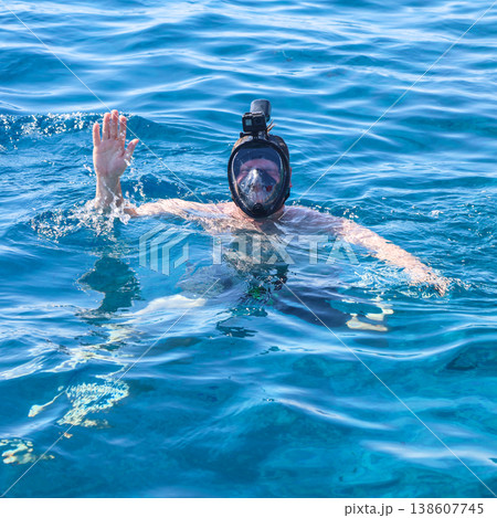 Adventurous Man Snorkeling in the Red Sea with a Snorkel Mask and Action Camera, Exploring Vibrant Marine Life and Underwater Wonders Adventurous Man Snorkeling in the Red Sea with a Snorkel Mask and Action Camera, Exploring Vibrant Marine Life and Underwater Wonders 138607745