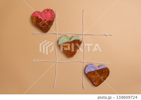 Creative tic tac toe food game Flat lay greeting card Valentine's Day Delicious fresh variety croissants topped with colorful flavor Ganache. Creation unique heart shape bakery. Puff pastry holiday 138609724
