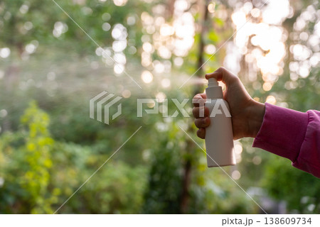 Unrecognizable woman using insect sprays disease prevention. Protection against mosquito bite during summertime. Safety skin treatment 138609734